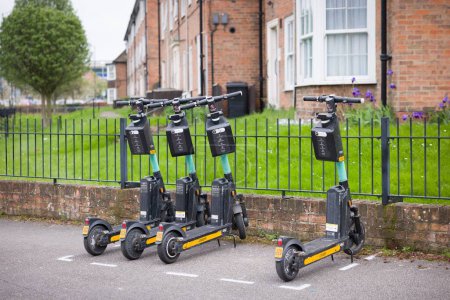 Téléchargez les photos : YORK, Royaume-Uni - 17 avril 2023. Rangée de scooters électriques de location (e-scooter) garés dans une rue de la ville à York, Royaume-Uni - en image libre de droit