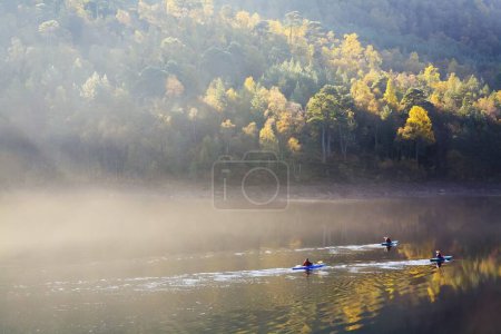 Téléchargez les photos : Les gens font du kayak sur un loch dans les Highlands écossais en automne. Glen Affric, Écosse, Royaume-Uni. Aucun visage reconnaissable. - en image libre de droit