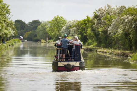 Foto de MILTON KEYNES, Reino Unido - 25 de mayo de 2023. Hombre y mujer manejan un bote estrecho en el Gran Canal de la Unión, Stony Stratford, Milton Keynes, Reino Unido - Imagen libre de derechos