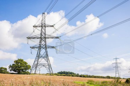 National grid energy network. Electricity pylons in UK countryside, rural landscape