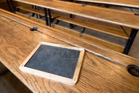 Téléchargez les photos : À l'intérieur d'une salle de classe ancienne avec des bancs en bois traditionnels et des tablettes d'ardoise, Royaume-Uni - en image libre de droit