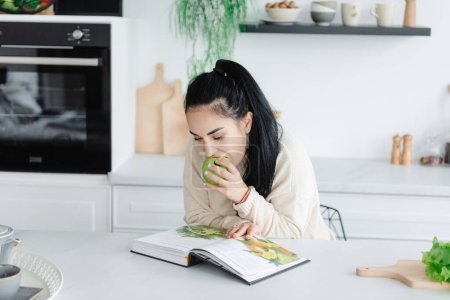 Photo for Healthy Eating. A young woman eats a lot of greens. Self-care. Woman reading a magazine about diet and healthy eating. - Royalty Free Image