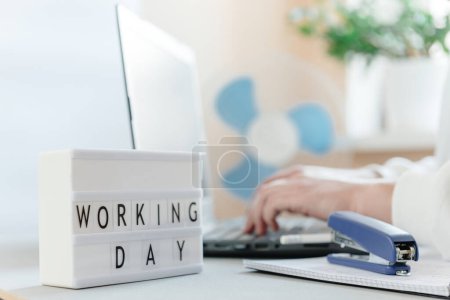 Photo for Workplace with a laptop, hands of a man, notepad on a white background. Freelancers workplace. Workday text inscription and blank space for text. - Royalty Free Image