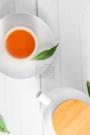 Foto de Vista superior o aplanado con té de hierbas en una taza y tetera sobre fondo de madera blanca, ceremonia del té, té tradicional chino o japonés. Foto de alta calidad - Imagen libre de derechos