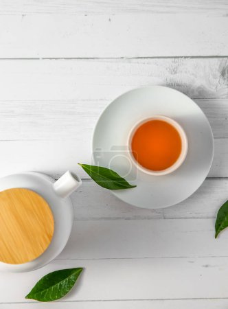 Foto de Vista superior o aplanado con té de hierbas en una taza y tetera sobre fondo de madera blanca, ceremonia del té, té tradicional chino o japonés. Foto de alta calidad - Imagen libre de derechos