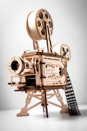 Téléchargez les photos : Maquette en bois d'un projecteur de cinéma, projecteur de film à l'ancienne sur fond gris clair. Photo de haute qualité - en image libre de droit