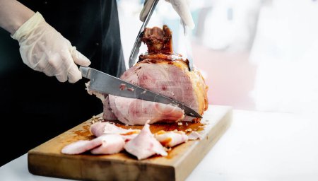 Photo for Chef or caterer slicing ham for cooking, catering, party, or meal time. High quality photo - Royalty Free Image