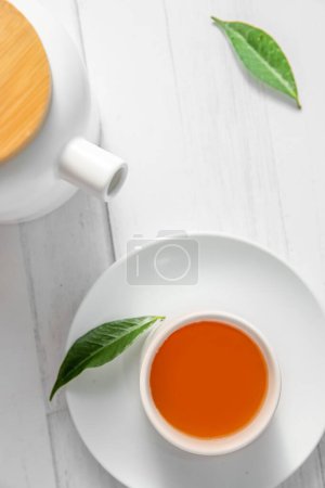 Téléchargez les photos : Vue de dessus ou flatlay avec tisane dans une tasse et théière sur fond blanc en bois, cérémonie du thé, thé traditionnel chinois ou japonais. Photo de haute qualité - en image libre de droit
