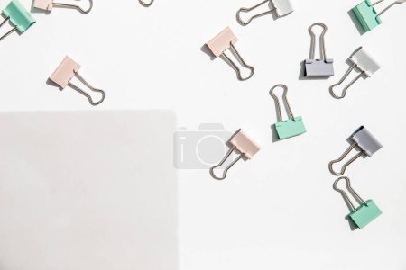 Photo for White note hold by metal paper clips isolated over white background, business concept, memory reminder paper, work or educational tools. High quality photo - Royalty Free Image