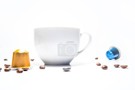 Foto de Taza de café blanco, cápsulas de café y granos alrededor, aislado sobre fondo blanco. Foto de alta calidad - Imagen libre de derechos