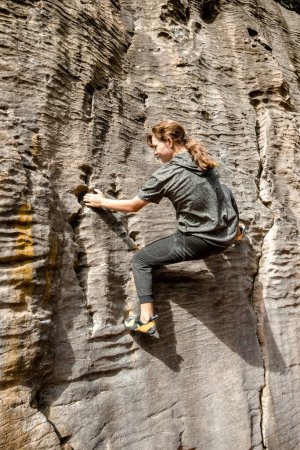 Téléchargez les photos : Jeune adolescente active faisant de l'escalade en plein air bloc sur une falaise naturelle. Photo de haute qualité - en image libre de droit