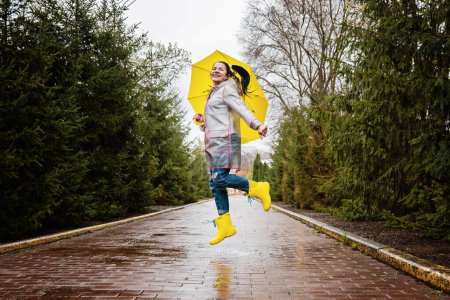 Photo for Autumn depression and how to deal with it. Seasonal affective disorder SAD. Happy senor woman in yellow rain boots and umbrella having fun and enjoy life in rainy autumn park. - Royalty Free Image