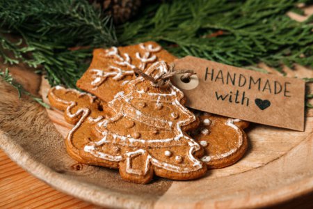 Téléchargez les photos : Aucun cadeau Idées de Noël pour la famille, Amis pour un Noël anti-consumériste. Biscuits au pain d'épice maison de Noël avec ruban, sapin et étiquette d'amour faite à la main sur une table en bois. - en image libre de droit