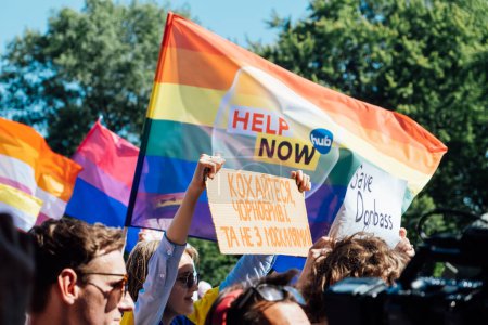 Foto de Orgullo gay, marcha de solidaridad LGBTQ con banderas de arco iris y carteles contra la guerra. Manos sosteniendo un afiche con afiches antiguerra. Desfile de Igualdad. Varsovia, Polonia, 25 de junio de 2022. - Imagen libre de derechos