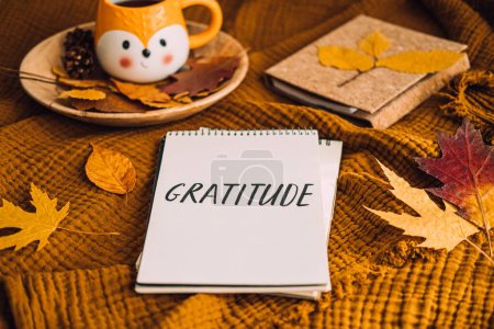 Wie man Dankbarkeit übt. Schreiben Herbst Dankbarkeit Tagebuch. Aufgeschlagene Notizbuchseiten mit Text Dankbarkeit und Herbstblätter braunes Bett. Beachten Sie gute Dinge, drücken Sie Dankbarkeit gegenüber sich selbst aus
