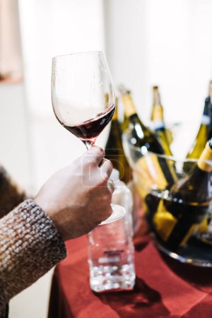 Téléchargez les photos : Deux amateurs de vin s'engagent dans l'expérience sensorielle de la dégustation de vin, évaluant la qualité d'un vin doré lors d'un salon. - en image libre de droit