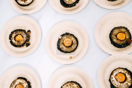 champignons farcis gastronomiques servis dans des assiettes individuelles pour un événement de restauration sophistiqué.