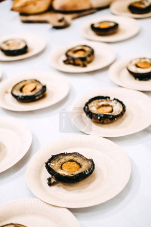 Photo for Gourmet stuffed mushrooms served on individual plates for a sophisticated catering event. - Royalty Free Image