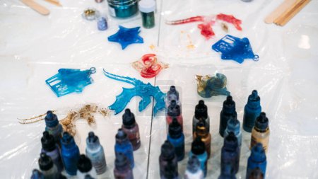 A detailed view of a crafting session where an individual is engaged in the process of making epoxy resin art, highlighting measuring and pouring techniques.
