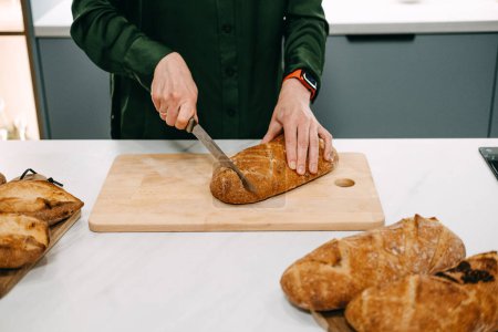 Hands gently arranging slices of freshly baked sourdough bread in a bowl, showcasing the art of traditional bread making.