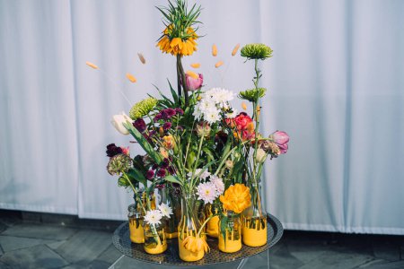An artful arrangement of diverse flowers stands tall in cheerful yellow-painted vases, creating an eye-catching ensemble that radiates with vibrancy and life.
