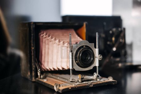 Photo for A vintage foldable bellows camera featuring an accordion-like extension and classic lens, resting on a tabletop. - Royalty Free Image
