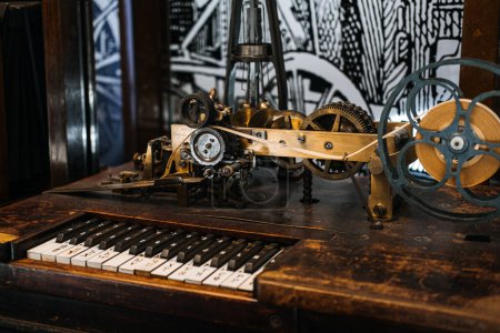 Photo for Historic telegraph apparatus with a complex mechanism and a coded keyboard, exhibited on a wooden table with artistic background. - Royalty Free Image