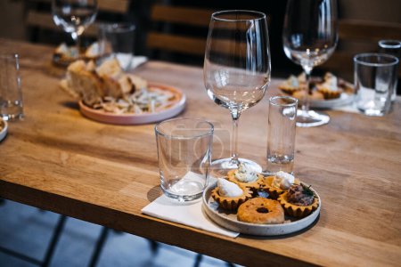 A beautifully curated tasting dinner highlighting local flavors, with meticulously arranged tartlets on a plate and expertly selected wine pairings.