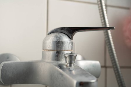 Foto de Old lime scale or calcium stained bathtub faucet from hard water. Close up detail shot, shallow depth of field, no people. - Imagen libre de derechos