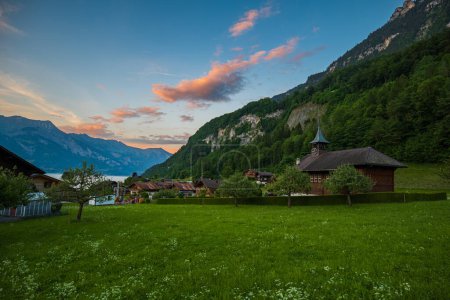 Téléchargez les photos : Beau coucher de soleil dans le célèbre petit village touristique d'Iseltwald, Suisse. Pas de peuple. - en image libre de droit