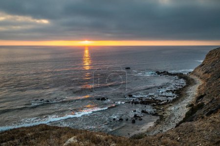 Alors que le soleil se couche sur Golden Cove, ses eaux tranquilles reflètent les tons chauds du ciel, offrant une évasion sereine au milieu des falaises escarpées de Rancho Palos Verdes, Californie.