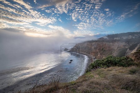 Experimenta la belleza de Rancho Palos Verdes mientras una capa marina cubre la costa, creando un fascinante paisaje nublado sobre escarpados acantilados y joyas ocultas como el faro de Point Vicente y Pelican Cove.