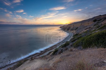 Embárcate en un viaje sereno a lo largo del Camino Catalina, donde la tranquila puesta de sol ilumina los escarpados acantilados y el esplendor costero de Ocean Trails Reserve, Rancho Palos Verdes, California.