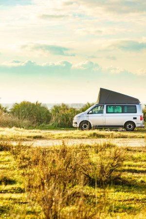 Van car equipped with camping gear roof tent camping on beach