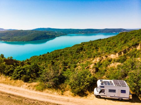 Camper with solar panels on roof camping at Sainte Croix Lake, Verdon Gorge in french Alps mountains, Provence France. Holidays trip.