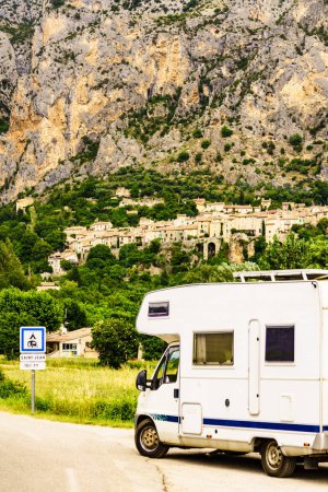 Camper rv and medieval rock village of Moustiers-Sainte-Marie in the distance, Provence in France. European vacation destination.