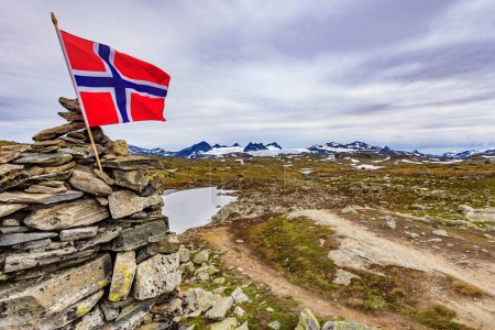 Hoher Steinstapel mit norwegischer Flagge. Nationale touristische Aussichtsstraße 55 Sognefjellet, Aussichtspunkt Mefjellet, Norwegen