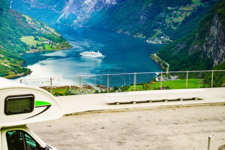 Camper car on Flydasjuvet viewpoint and fjord Geirangerfjord with cruise ship, Norway. Travel destination.