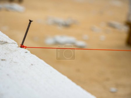 String being used as level in the construction of wall. Bricklayer