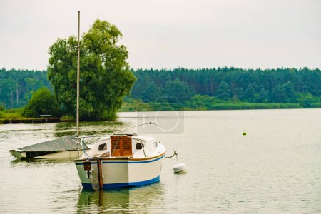 Bootsjacht auf dem See, die an Ankerboje befestigt ist. Tuchola Nationalpark in Polen. Yachting, Urlaubskonzept.
