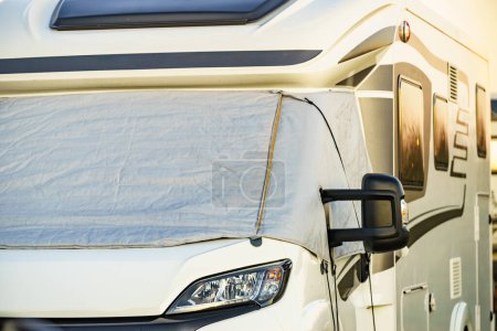Camper with external thermal screen blind at window pane, front windscreen of the car. Camping on nature. Holidays and travel in motor home.