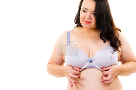 Más tamaño mujer madura grasa con sujetador, en blanco. Pecho femenino en lencería. Concepto de senos, brafitting y ropa interior.