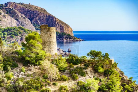 Coastal landscape with watchtower. Torre Del Pino, tower on cliffs of Maro Cerro Gordo Natural Park, near Nerja, Malaga province, Costa Del Sol, Andalusia, Spain.