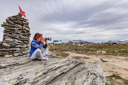 Mujer turista disfrutar de montañas paisaje, tomar fotos de viaje con cámara. Ruta turística nacional 55 Sognefjellet, Noruega