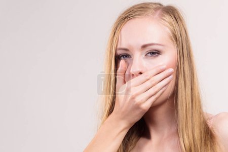 Schockierte Frau bedeckt ihren Mund mit der Hand, erschrocken oder verängstigt. Frauen sehen etwas Schockierendes und Sprachloses.