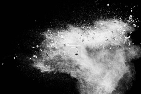 Foto de White powder with small stones on black background. Small granite rock stone fly on dust against dark background. - Imagen libre de derechos