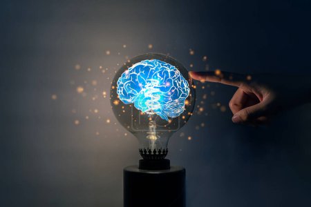 Businessman hand touching lightbulb with glowing virtual brain and connection line to creative smart thinking for inspiration and innovation with network concept.