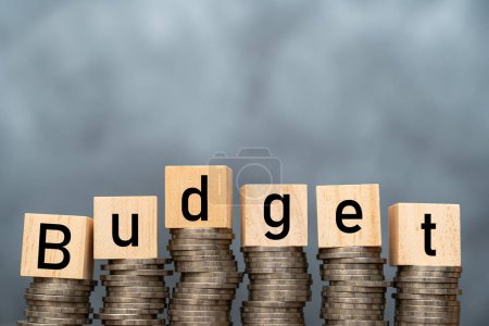 Photo for Money annual budget concept. stacked coins and wooden cubes with word Budget on coins background. Free space for advertising materials - Royalty Free Image