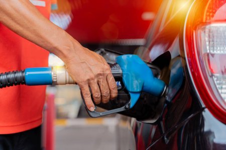 Photo for Refueling the car at a gas station fuel pump. Man driver hand refilling and pumping gasoline oil the car with fuel at he refuel station. Car refueling on petrol station. Fuel pump at station - Royalty Free Image