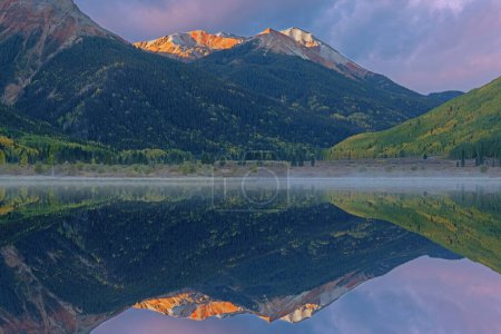 Téléchargez les photos : Foggy paysage d'automne au lever du soleil de Crystal Lake et Red Mountain avec des reflets miroirs dans l'eau calme, Montagnes San Juan, Colorado, États-Unis - en image libre de droit